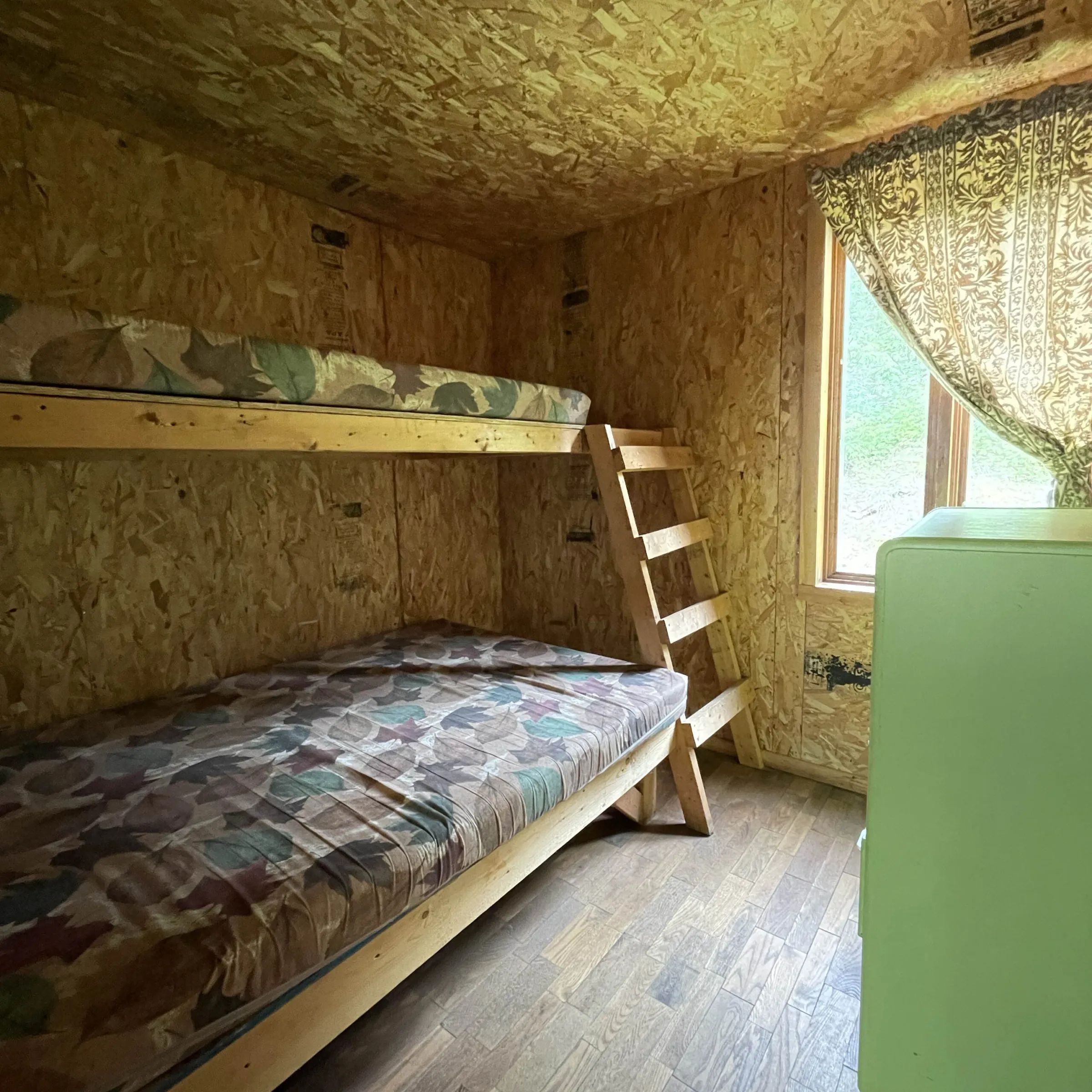 Cette chambre rustique du chalet comprend des lits superposés en bois.