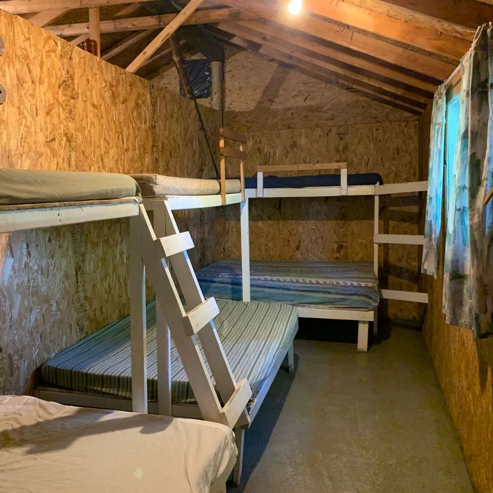 This rustic bedroom is equipped with several wooden bunk beds.