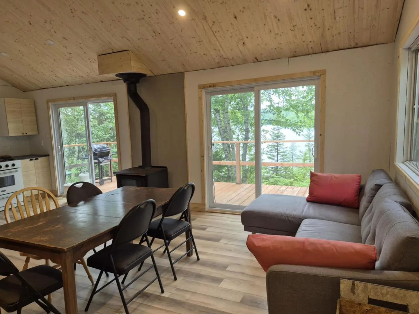 View of the open concept living area featuring the dining room, living room, and a wood stove.