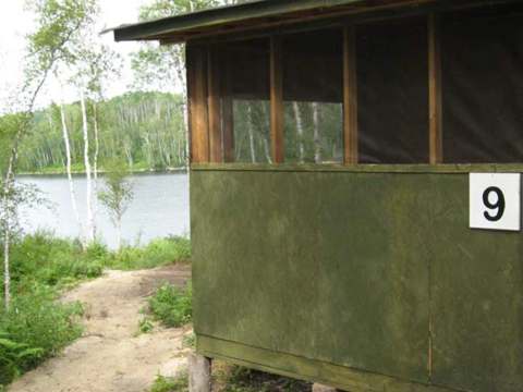 Side view of cabin number nine with its path leading towards the lake.