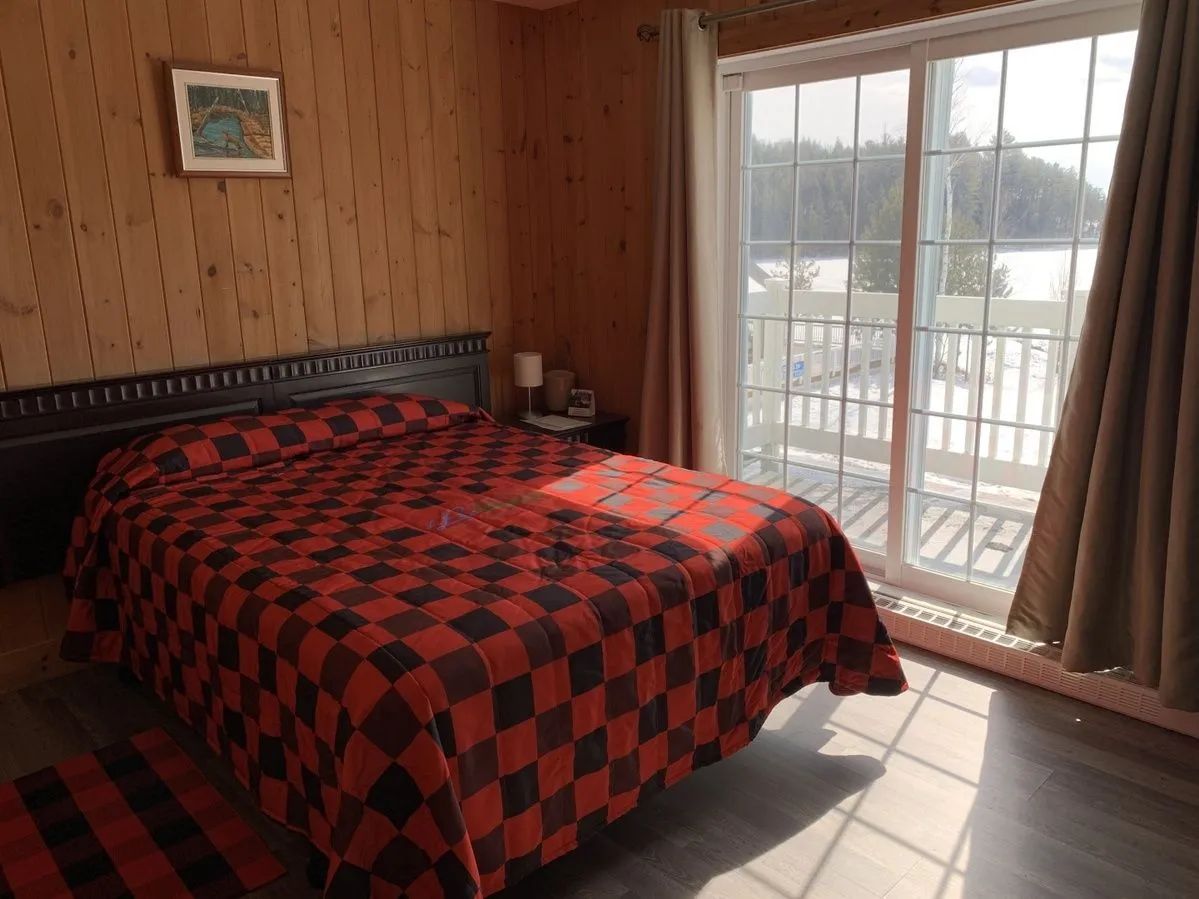 This classic room features a comfortable bed and direct access to a balcony with a lake view.