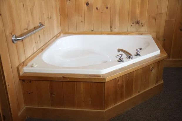 Cette chambre supérieure dispose d'une baignoire en coin avec lambris de bois.