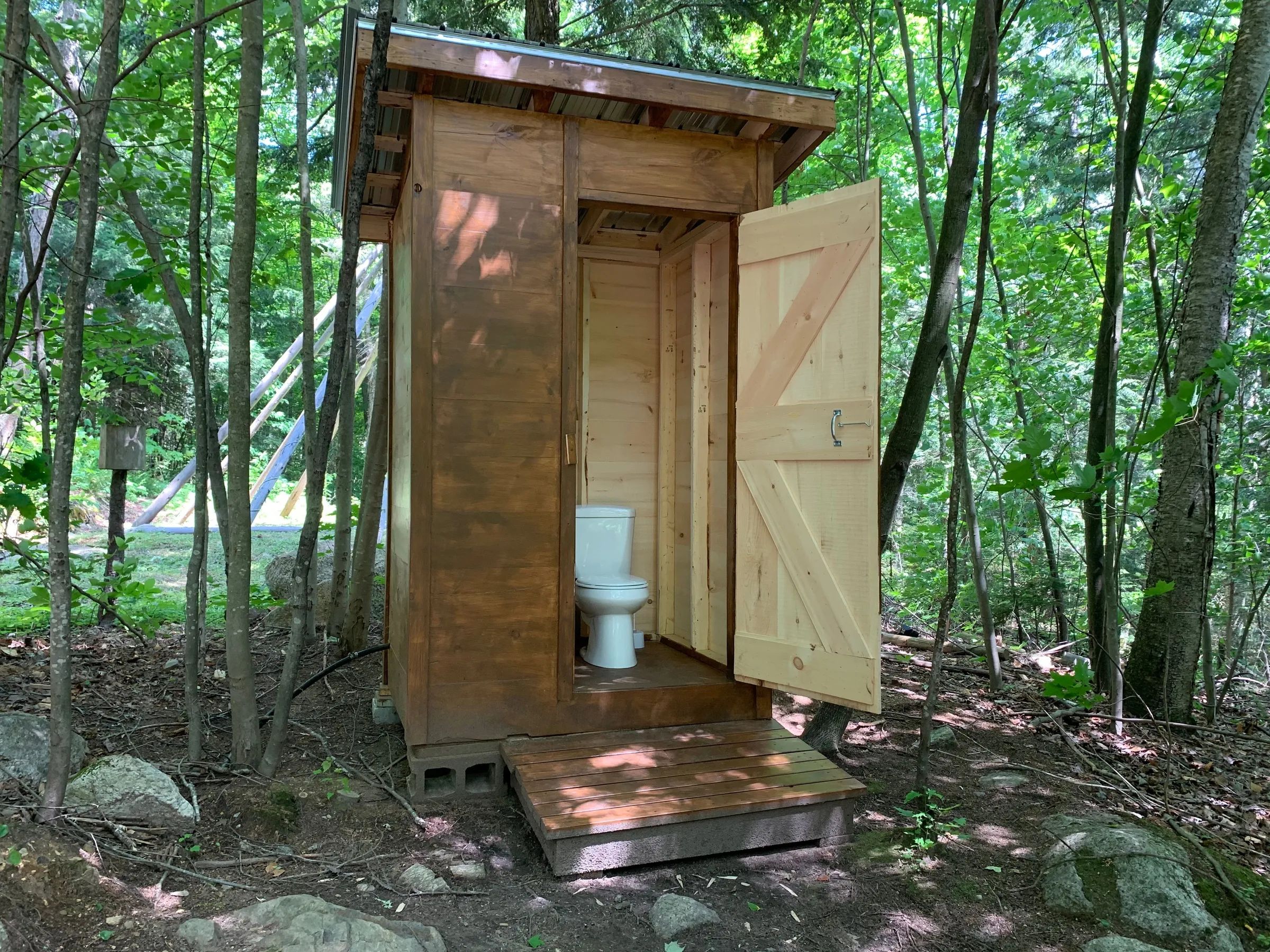 Une toilette extérieure en bois est mise à la disposition des occupants du prêt-à-camper.