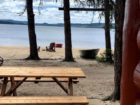 View of the beach and lake from the Mésange cabin with its outdoor picnic table.