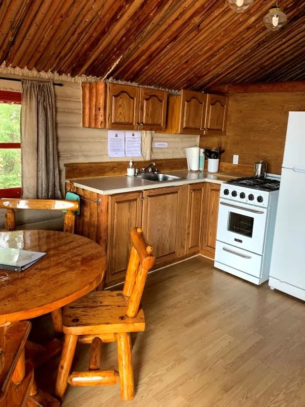 The functional kitchen in the Mésange cottage includes a stove, refrigerator, and a dining table.