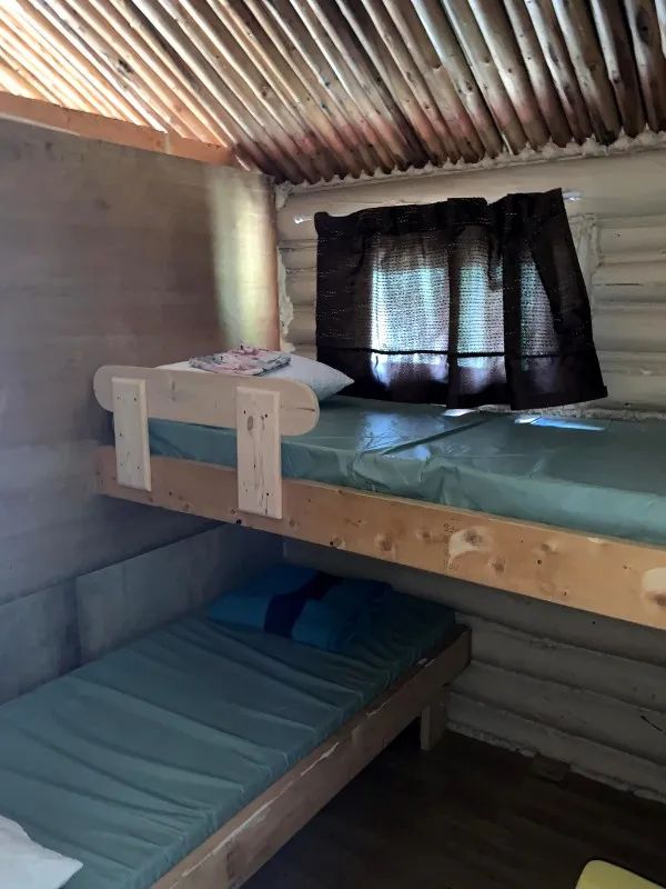 The Mésange cabin bedroom is equipped with wooden bunk beds.