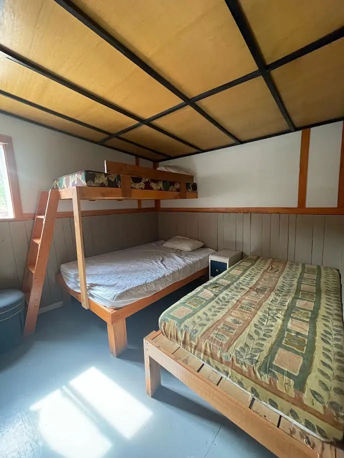 Cette chambre du chalet comprend un lit simple superposé et un lit simple au sol.
