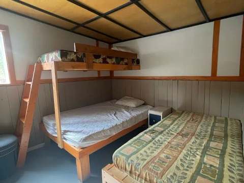 Cette chambre du chalet comprend un lit simple superposé et un lit simple au sol.
