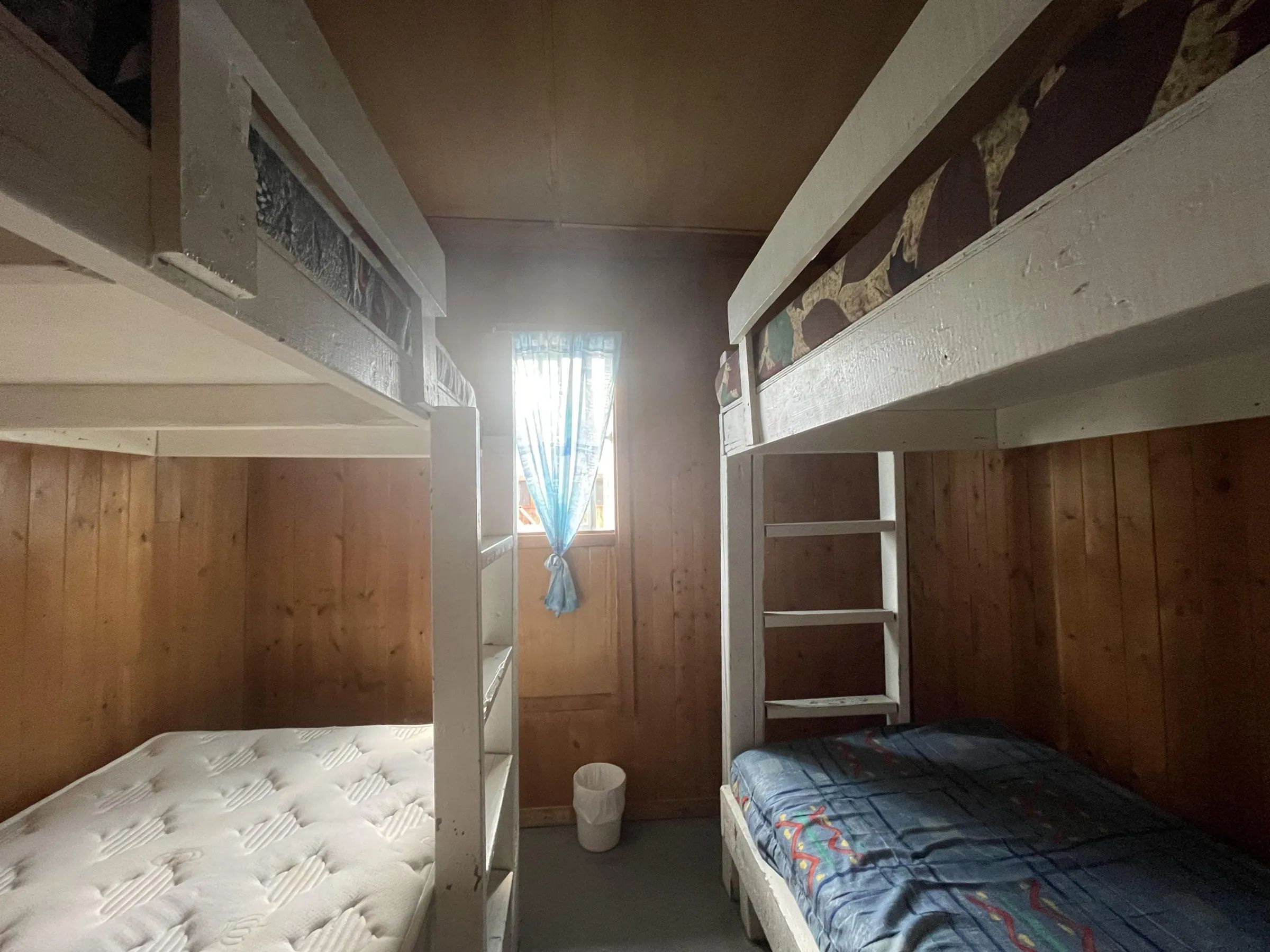 Cette chambre de chalet comprend deux lits superposés en bois avec matelas.