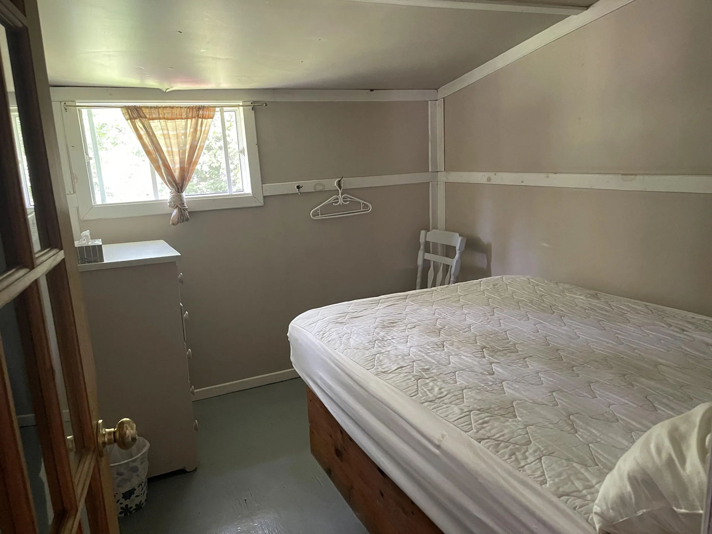 Cette chambre lumineuse du chalet 5 comprend un lit double avec matelas ainsi qu'une commode.