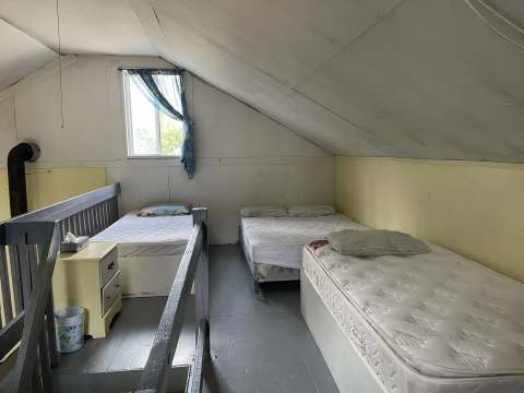 Cette chambre sous le toit du chalet comprend plusieurs lits pour votre confort.