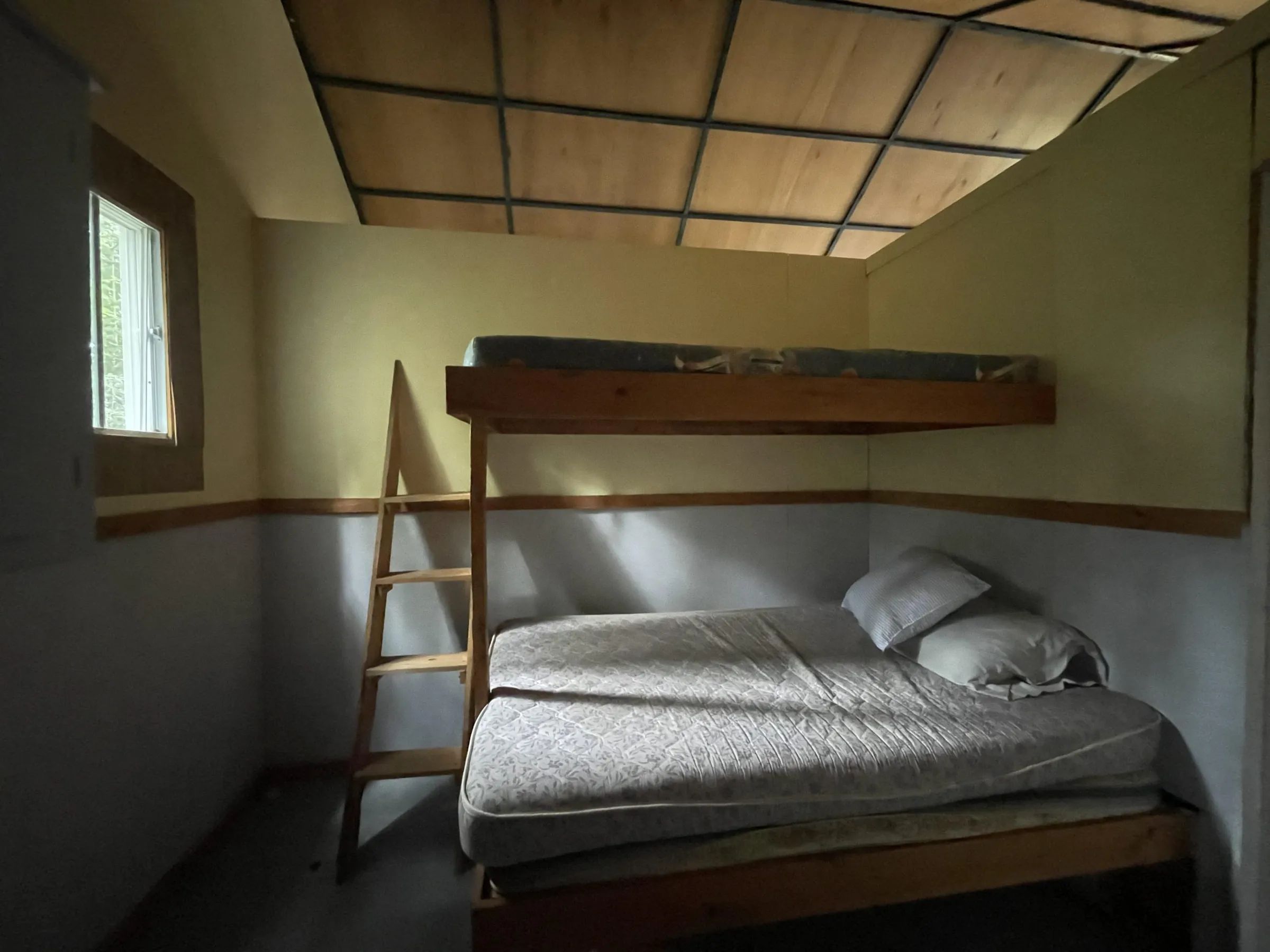Cette chambre du chalet comprend un lit superposé avec un lit double au niveau inférieur.