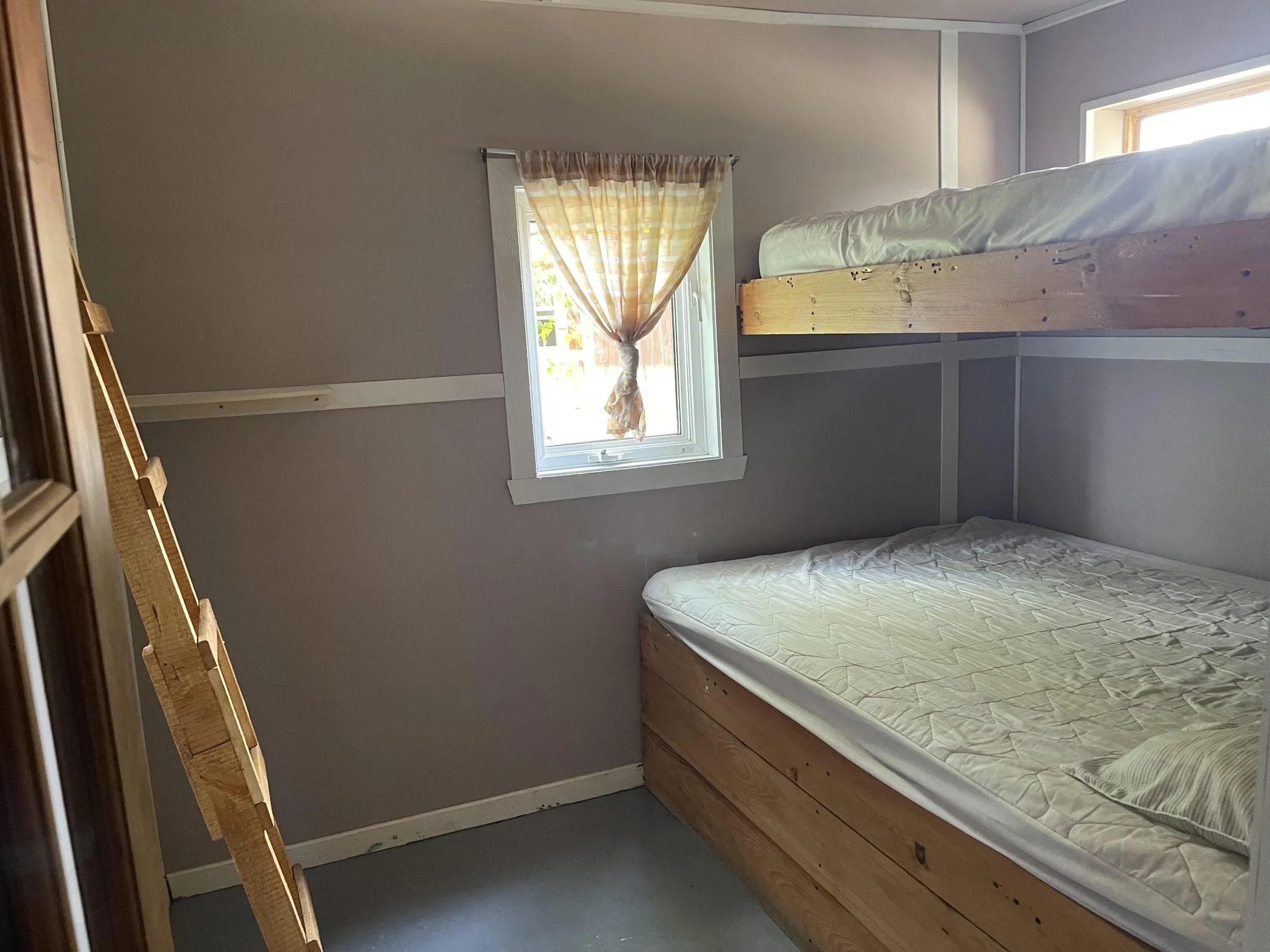 Cette chambre du chalet dispose d'un lit superposé avec une fenêtre offrant de la lumière naturelle.