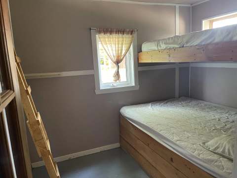 Cette chambre du chalet dispose d'un lit superposé avec une fenêtre offrant de la lumière naturelle.