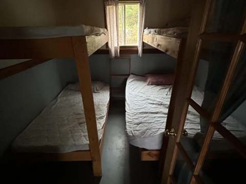 Cette chambre de chalet comprend des lits superposés en bois.