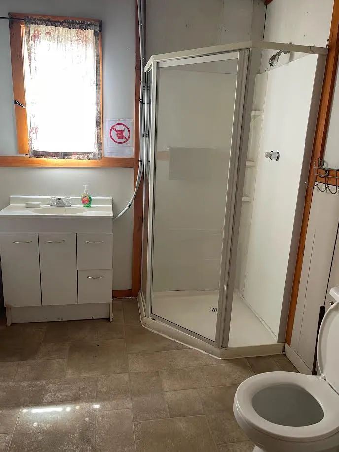 La salle de bain du chalet comprend une douche, un lavabo et une toilette.