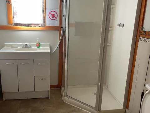 La salle de bain du chalet comprend une douche, un lavabo et une toilette.