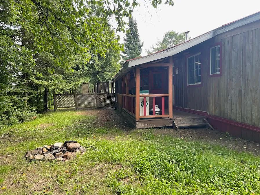 Side view of cabin 6 featuring its covered deck and outdoor fire pit area.