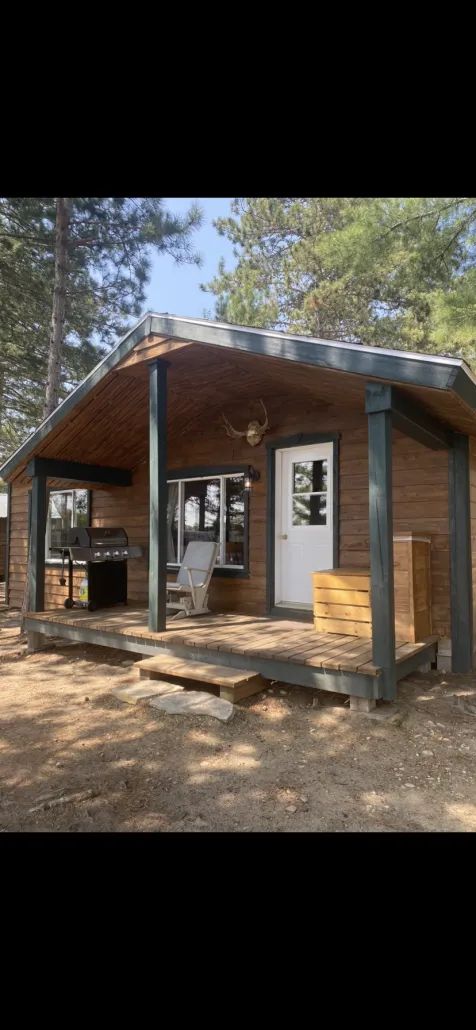 Exterior view of cabin 2 with its covered deck, barbecue, and outdoor seating.