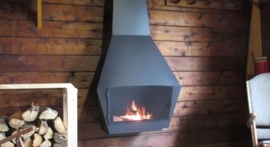 A hanging fireplace warms the wooden interior of our cottage.