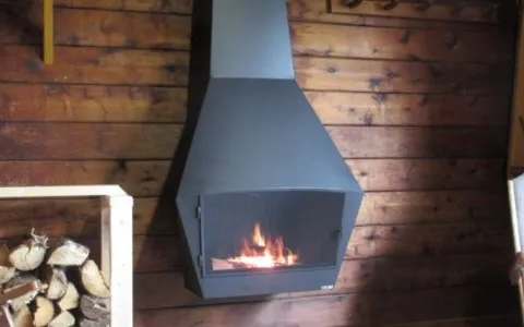 A hanging fireplace warms the wooden interior of our cottage.