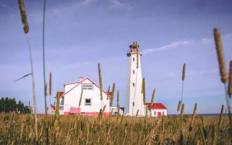 A white cottage with a red roof located near the island's iconic lighthouse.