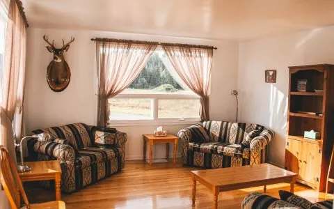 A cozy living room featuring comfortable sofas and decor inspired by the world of hunting.