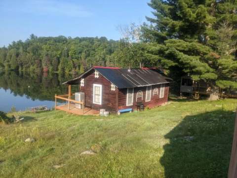 Le chalet numéro 1 est situé au bord de l'eau avec une terrasse et une vue sur la forêt.