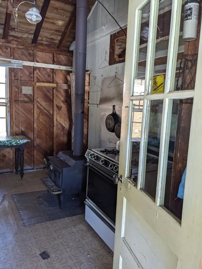 Vue sur la cuisine et le poêle à bois à l'intérieur du chalet.