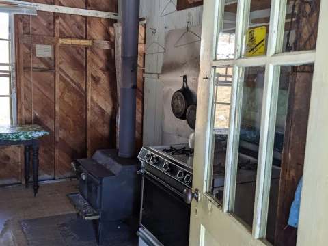 Vue sur la cuisine et le poêle à bois à l'intérieur du chalet.