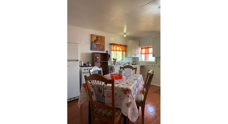 This equipped kitchen and dining area are located inside the cabin.