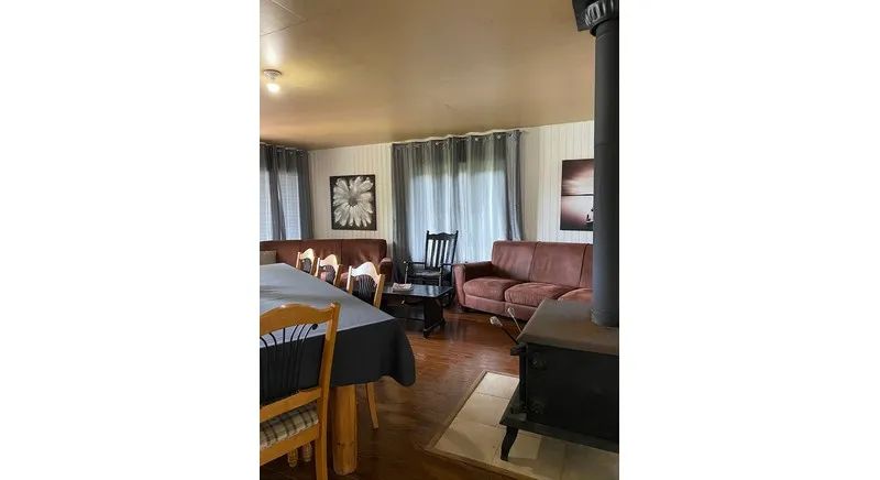 The cottage's living and dining area offers a relaxation space with a fireplace and comfortable sofas.