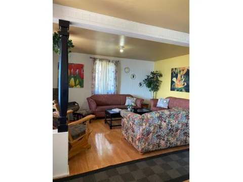 The living room of chalet 15 features comfortable sofas and hardwood flooring.