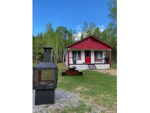 Exterior view of the cabin with its picnic table and outdoor fire pit.