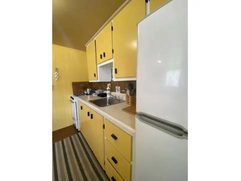 The cabin's equipped kitchen features a refrigerator, stove, and a functional sink.