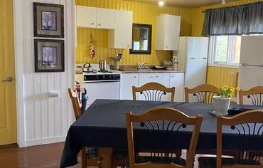 The cottage's equipped kitchen and dining area are ready to welcome you.