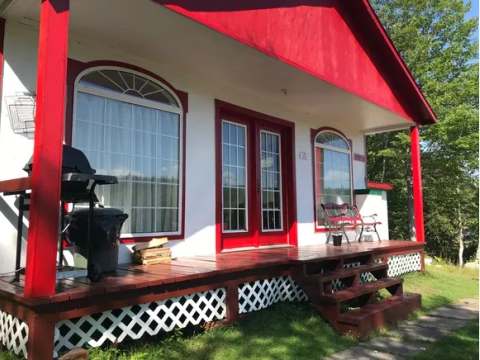 The gallery of cabin number twenty includes a barbecue and an outdoor bench.