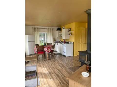 The cottage kitchen and dining area are equipped with a wood stove and household appliances.