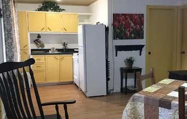 The chalet's equipped kitchen features yellow cabinets and a refrigerator.