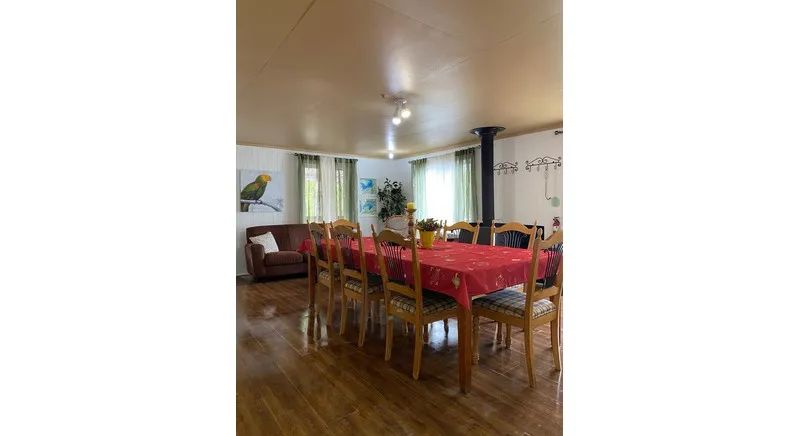 The dining room and living room share an open and bright space in the cabin.