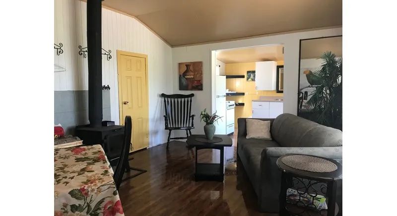 The chalet's living area features a lounge space with a sofa and a wood stove.