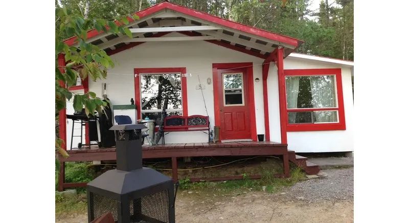 Front view of cabin number 5 with its deck and outdoor fireplace.