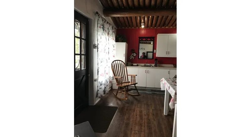 The kitchen in cottage #7 features a cozy space with a wooden rocking chair.