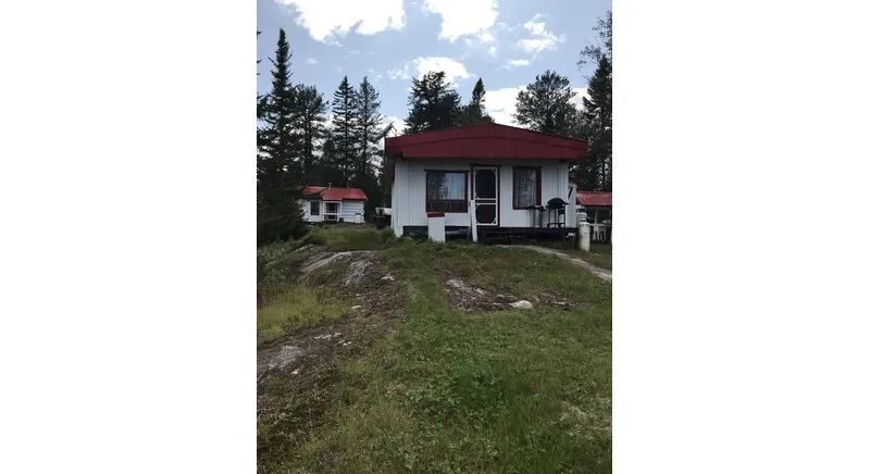 Exterior view of cabin number 7 located in the forest.
