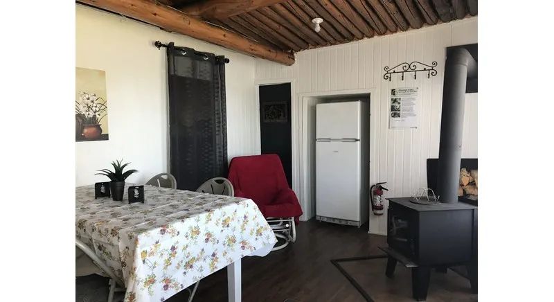 The cottage dining area features a table and a wood stove for your comfort.