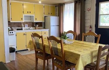 The cottage's equipped kitchen and dining area include a family table and major appliances.