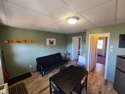 The Bear Studio features an open area with a sofa bed and a dining table.