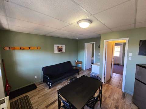 The studio's living area includes a table, a sofa bed and a view into the other rooms.