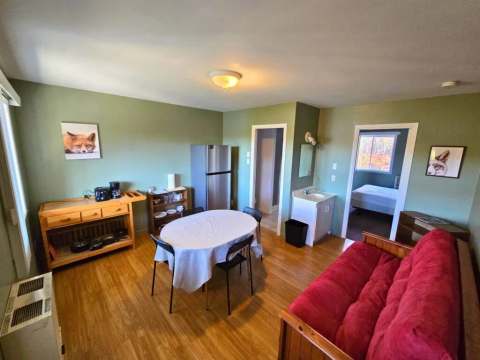 Open-concept living space including a dining area, a compact kitchen, and a lounge corner.