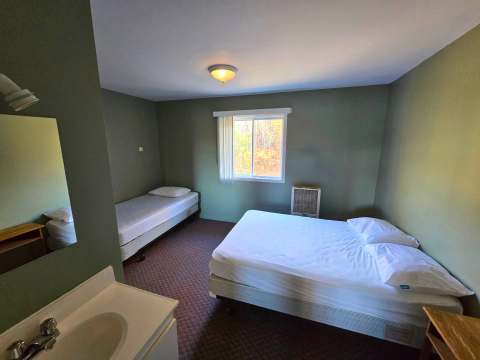 The Studio Le Renard features two beds and an integrated bathroom sink.